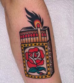 a tattoo on the arm of a man with a rose in a box and candles