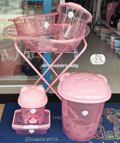 two pink plastic containers sitting next to each other on a blue rug in front of a store window