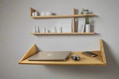 a laptop computer sitting on top of a wooden shelf