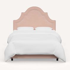 a bed with a pink headboard and white sheets on it's sides, in front of a light gray background