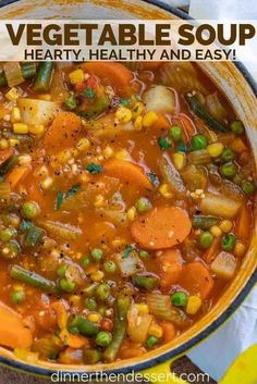 a pot filled with vegetable soup on top of a wooden table