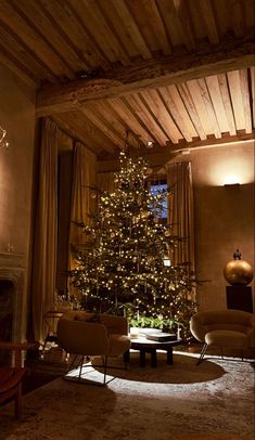 a living room filled with furniture and a christmas tree in the middle of the room