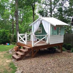 a small white house sitting on top of a wooden deck