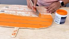 a woman is using a knife to cut out strips of wood