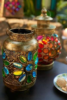 three decorative vases sitting on top of a table next to plates and cups filled with food