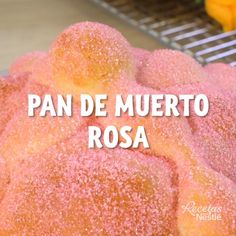 a pile of powdered sugar covered donuts sitting on top of a metal rack