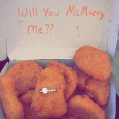 a box filled with fried food next to a sign that says will you marry me?