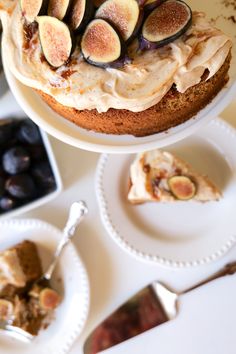 a cake with figs on top is sitting on a plate next to other desserts