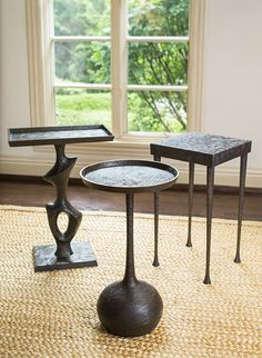 two tables sitting on top of a rug in front of a window next to each other