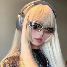 a woman wearing headphones and sunglasses with long blonde hair is looking at the camera