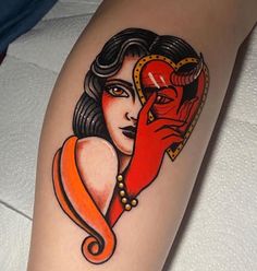 a woman's arm with a red heart and horns tattoo on her left thigh