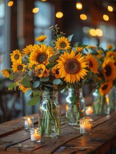 sunflowers are in mason jars with candles on a wooden table at a wedding