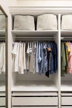 an organized closet with clothes hanging on rails and folded shirts in the bottom drawer,