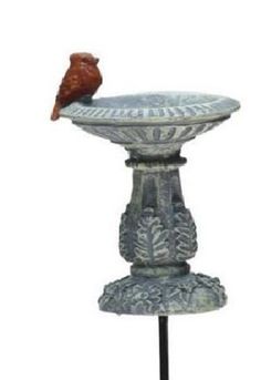 a bird is perched on top of a pedestal