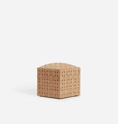 a small wooden block sitting on top of a white surface with holes in the middle