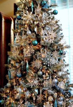 a decorated christmas tree with blue and silver ornaments