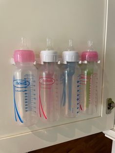 three baby bottles are hanging on the wall