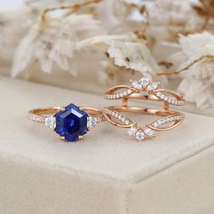 two gold rings with blue and white stones on them, one is set next to the other