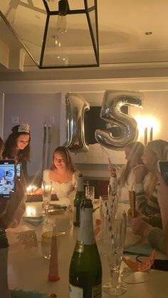 a group of people sitting around a table with drinks and candles in front of them