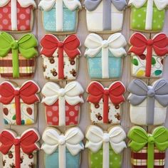 decorated cookies in the shape of gift boxes with bows and ribbons are displayed on a table