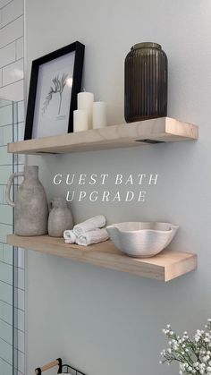 two wooden shelves with white towels and vases on them, one shelf is holding a bowl