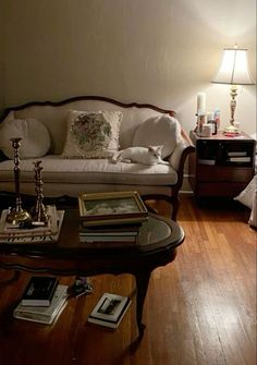 a living room filled with furniture and a lamp on top of a wooden table in front of a white couch