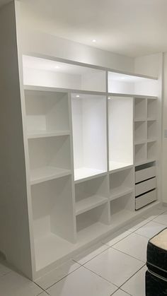 an empty room with white shelving in it