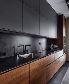 a kitchen with black counter tops and wooden cabinets