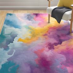 a colorful area rug with an abstract design on the floor in front of a chair