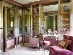 a fancy bathroom with pink and gold decor on the walls, mirrored cabinet doors, and marble flooring