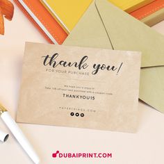 a thank you card sitting on top of an envelope