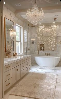 a large bathroom with a tub, sink and chandelier hanging from the ceiling