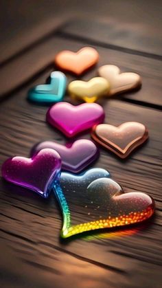 colorful hearts are arranged on a wooden table