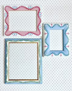 three different colored frames sitting next to each other on a white tablecloth covered wall