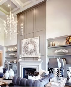 a living room filled with lots of furniture and a chandelier hanging from the ceiling