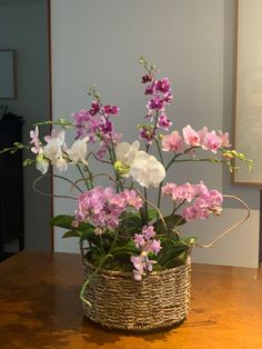 purple and white flowers in a basket on a table