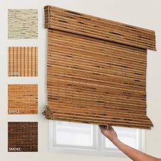 bamboo blinds with different shades and colors are being held up to the window by someone's hand