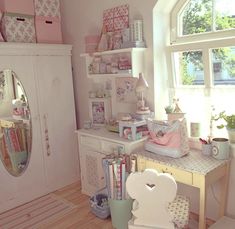 a room filled with lots of pink and white furniture next to a large window on top of a hard wood floor