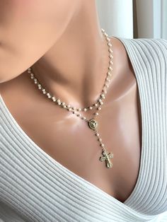 This is a beautiful pearl gold-filled rosary necklace made for women. This is a double strand pearl necklace made with 4 mm freshwater pearls on 14k gold filled chain. Both strands connect in back with a spring clasp.  Necklace charms are 18k gold filled. Beautiful Saint Michael rosary center measures 19 x 12 mm. Drop with cross measures, 3". This sparkling crucifix cross has pave crystals and measures 30 x 21 mm.  Necklace on model is 15 inch length. The length is the measurement of the top strand, around your neck. Please choose your desired length. It's always best to measure your neck since people have different neck sizes. Model in picture has a very slender neck. Comes in a gift box ready to present. Delicate Cross Jewelry For Wedding, Elegant Pearl Crucifix Necklace, Elegant Crucifix Pearl Necklace, Elegant Gold Rosary As Gift, Elegant Gold Rosary For Gift, Elegant Crucifix Necklace With Pearl Pendant, Elegant Crucifix Pearl Pendant Necklace, Elegant Gold Rosary For Anniversary, Elegant Crucifix Necklace For First Communion