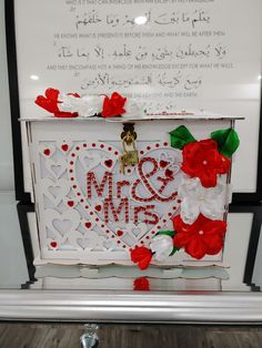 a white box decorated with red flowers and hearts