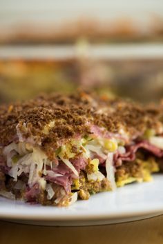 a sandwich with meat and vegetables on a white plate