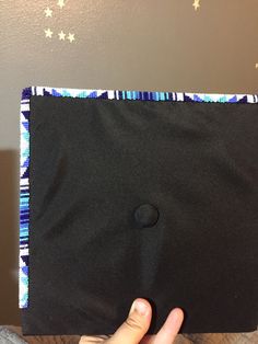 a person holding up a black piece of cloth