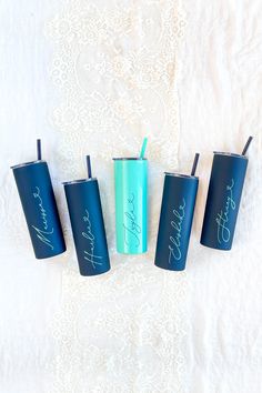 four personalized tumblers sitting on top of a white bed next to each other