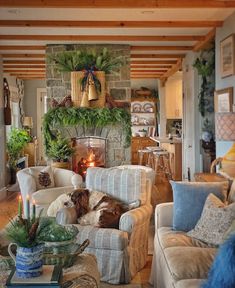 a living room filled with furniture and a fire place in the center surrounded by greenery