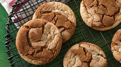 several cookies on a cooling rack with one muffin in the middle and four out