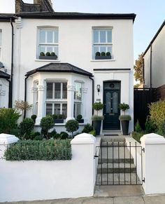 this is an image of a house with white walls and black trimmings on the front door