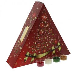 a triangle shaped box with candles in front of it and a christmas tree on top