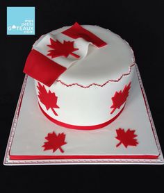 a white cake with red maple leaves on it