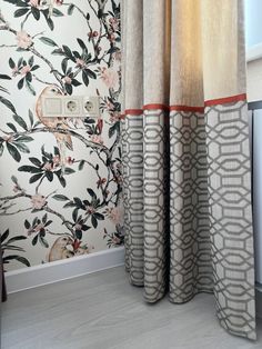 a bathroom with floral wallpaper and curtains