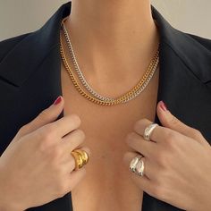 a woman wearing two different rings on her chest and holding onto the other ring that is attached to her breast